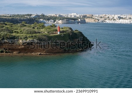 red lighthouse on L'Illa del Rei hospital island in the middle of the main navigable entry channel to Mahon in Menorca in the Mediterranean sea