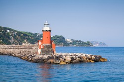 Red Lighthouse Tower On The Breakwater. Entrance To Ischia Porto. Mediterranean Sea, Italy