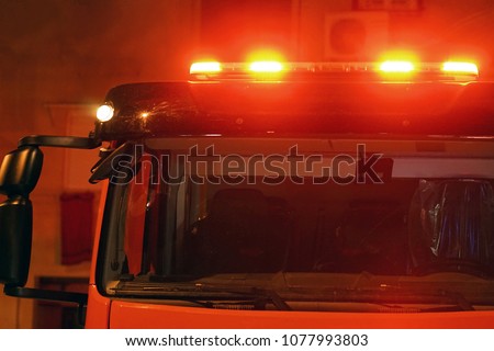 Red lights of a fire engine. Night time. Fire engine. Extinguishing the fire. Close-up of the red lights on top of a fire engine.