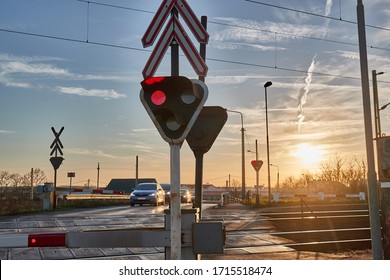 Red lights at a railway crossing, cars waiting for the train to pass
