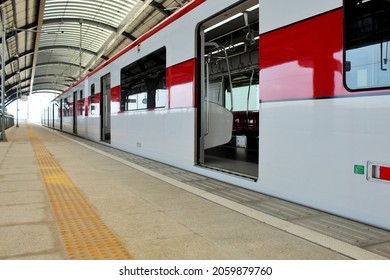 The red line train stops at the platform to transport passengers to the next station.