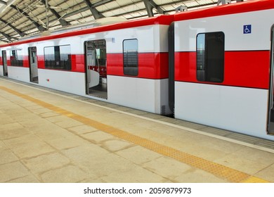 The red line train stops at the platform to transport passengers to the next station.