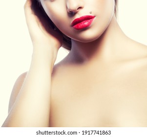 Red lips. Beautiful face of young caucasian woman with natural make-up, perfect skin, bright lipstick touching her cheek. Studio portrait