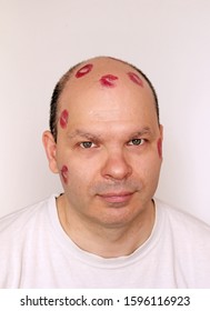 Red Lipstick Kisses Marks On Young Man With Bold Head