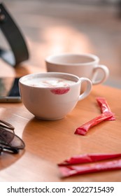 Red Lipstick Mark On A Coffee Cup On The Table In Cafe