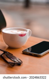 Red Lipstick Mark On A Coffee Cup On The Table In Cafe