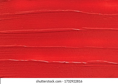 Red lipstick texture background. Makeup beauty product swatch smear smudge. Creamy matte lipstick strokes