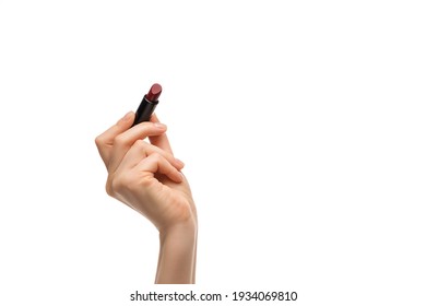 Red lipstick in a woman's hand on a white background, isolated.