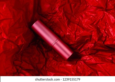 Red Liptick On Crumpled Paper Background Made From A Christmas Red Sheet Of Wrapping Paper For Presents