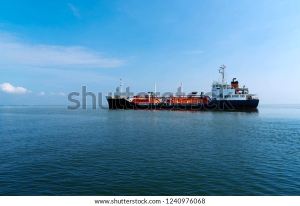 Red\
Liquefied Petroleum Gas LPG tanker in the sea out of the port in\
gulf of Thailand. Cargo ship against blue ocean.\
