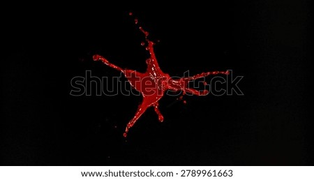 Red liquid splash isolated on black background resembling blood or red wine with realistic droplets for VFX overlay and cinematic visual effects