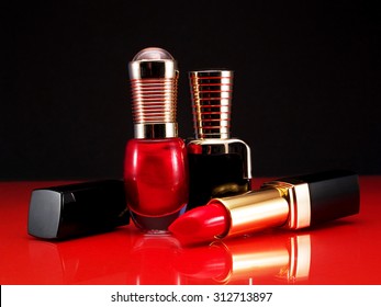Red listick and nail polish shot over reflective background