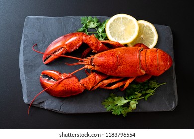red lobster with vegetable and lemon on black slate plate