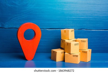 Red location pin pointer symbol and cardboard boxes. Improving the efficiency, speed and low cost of delivering goods to consumer. Business adaptation to quarantine measures, transition to online work