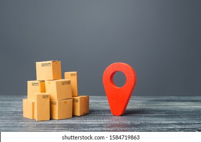 Red Location Pointer Geolocation Symbol And Cardboard Boxes. Distribution Delivery Of Goods, Freight Transportation Shipment. Logistics And Warehousing. Global Market And Business, Import And Export.