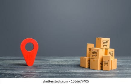 Red Location Pointer Geolocation Symbol And Cardboard Boxes. Distribution Delivery Of Goods, Freight Transportation Shipment. Logistics And Warehousing. Global Market And Business, Import And Export.