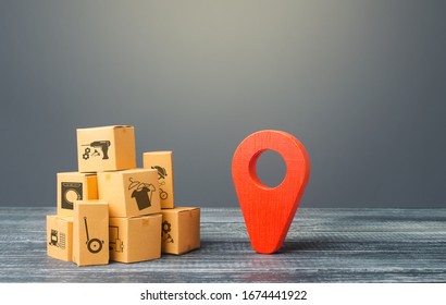 Red Location Pointer Geolocation Symbol And Cardboard Boxes. Global Market And Business, Import And Export. Distribution Delivery Of Goods, Freight Transportation Shipment. Logistics And Warehousing.