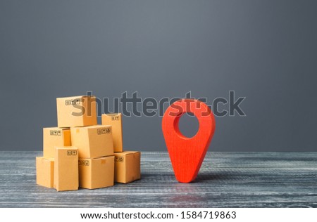 Red location pointer geolocation symbol and cardboard boxes. Distribution delivery of goods, freight transportation shipment. Logistics and warehousing. Global market and business, import and export.