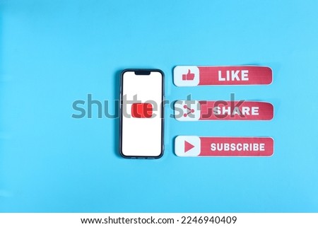 A red logo on smartphone screen with like share and subscribe text