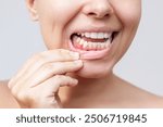 A red lump on the gum near the tooth. Gingivitis, gum inflammation. Cropped shot of a young woman showing red inflamed gums isolated on a white background. Close up. Dentistry, dental care