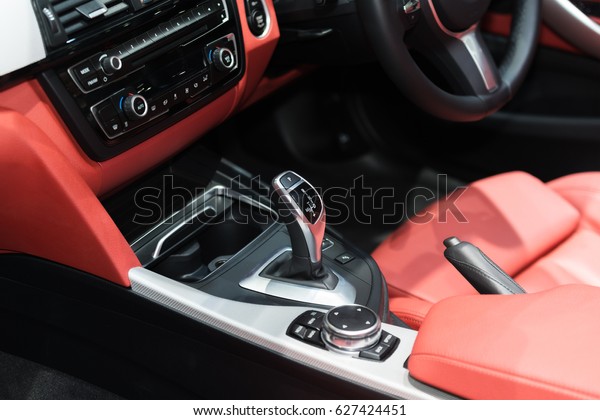 Red luxury car\
Interior with steering wheel, shift lever and air condition and\
radio button control in car