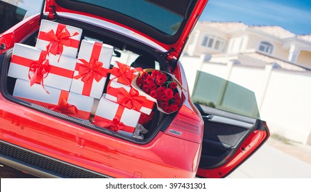 Red Luxury Car With Trunk Full Of Gift Boxes. Presents For Holiday. Car, Presents. Holidays, Happiness. Street Outdoor 