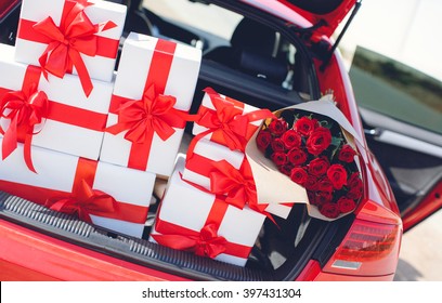 Red Luxury Car With Trunk Full Of Gift Boxes. Presents For Holiday. Car, Presents. Holidays, Happiness. Street Outdoor 