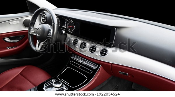 Red\
luxury modern car Interior. Steering wheel, shift lever and\
dashboard. Detail of modern car interior. Automatic gear stick.\
Part of leather seats with stitching in expensive\
car