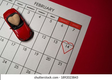 The red machine with a beige heart stands on the calendar 2021 on which is highlighted by the heart on February 14. Valentines day - Shutterstock ID 1892023843