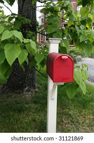 red mailbox in front of tree