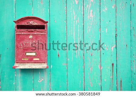 Red mailbox with green wood background