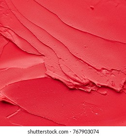 Red Makeup Smears Of Lip Gloss  Background. Broken Red Cream Lipstick Texture Background