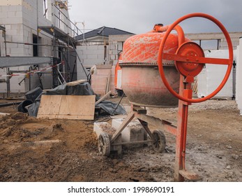 A Red Manual Cement Mixer In A Construction Site