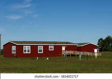 Red Manufactured Home In A Senior Community Features A Handicap Ramp, One Floor Living, And A Garage