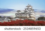 Red maple leaves in autumn and Himeji Castle with evening sky in Himeji city Hyogo Prefecture of Japan.