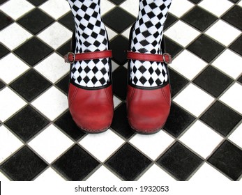 Red Mary Jane Shoes Worn With Black And White Checkered Tights On Checkered Tile Floor