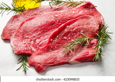 A Red Meat With Rosemary On Marble Table