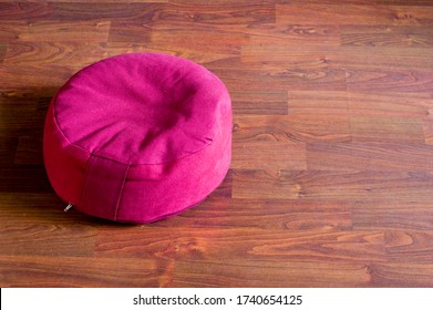 Red Meditation Cushion On Brown Wooden Floor