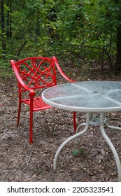 A Red Metal Chair And A White Table