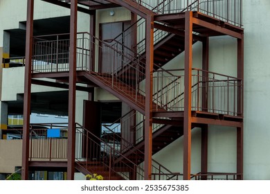 Red metal fire escape staircase of a building in an urban area during daylight hours
 - Powered by Shutterstock