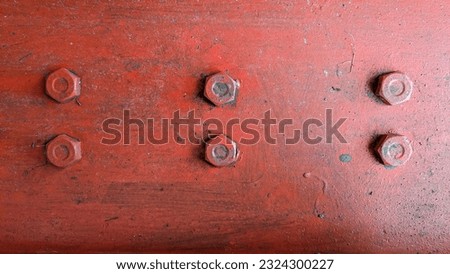 Red metal plate painted steel bolt screws in parallel lines as texture background