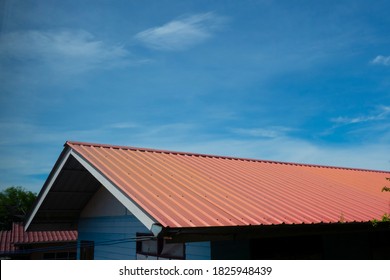 red metal sheet roof with blue bright sky with cloud.