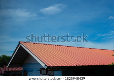 red metal sheet roof with blue bright sky with cloud.