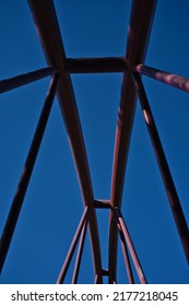 Red Metal Structure Of A Bridge Against The Blue Sky. Modern Architecture Background