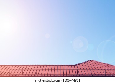 Red Metalic Roof Of Comercial Building. Summer. Lens Flare Effect