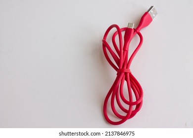 Red Micro Usb Charger For Handphone. Cable Phone Chargers On White Background. Red Cable With USB And Micro USB Connectors Isolated On A White Background. Smart Phone Charger Cables