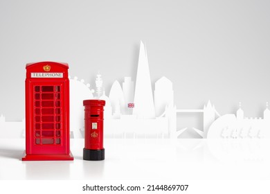 Red model telephone and post box and London skyline concept