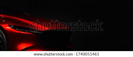 Red modern car headlights on black background	