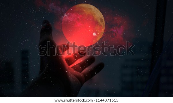 Red moon in hand, the power of the\
cosmos, neon light, galaxy, magic. moon eclipse - planet red blood\
with clouds - moon map element furnished by\
NASA