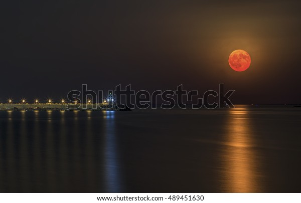 Red moon rise over the\
sea